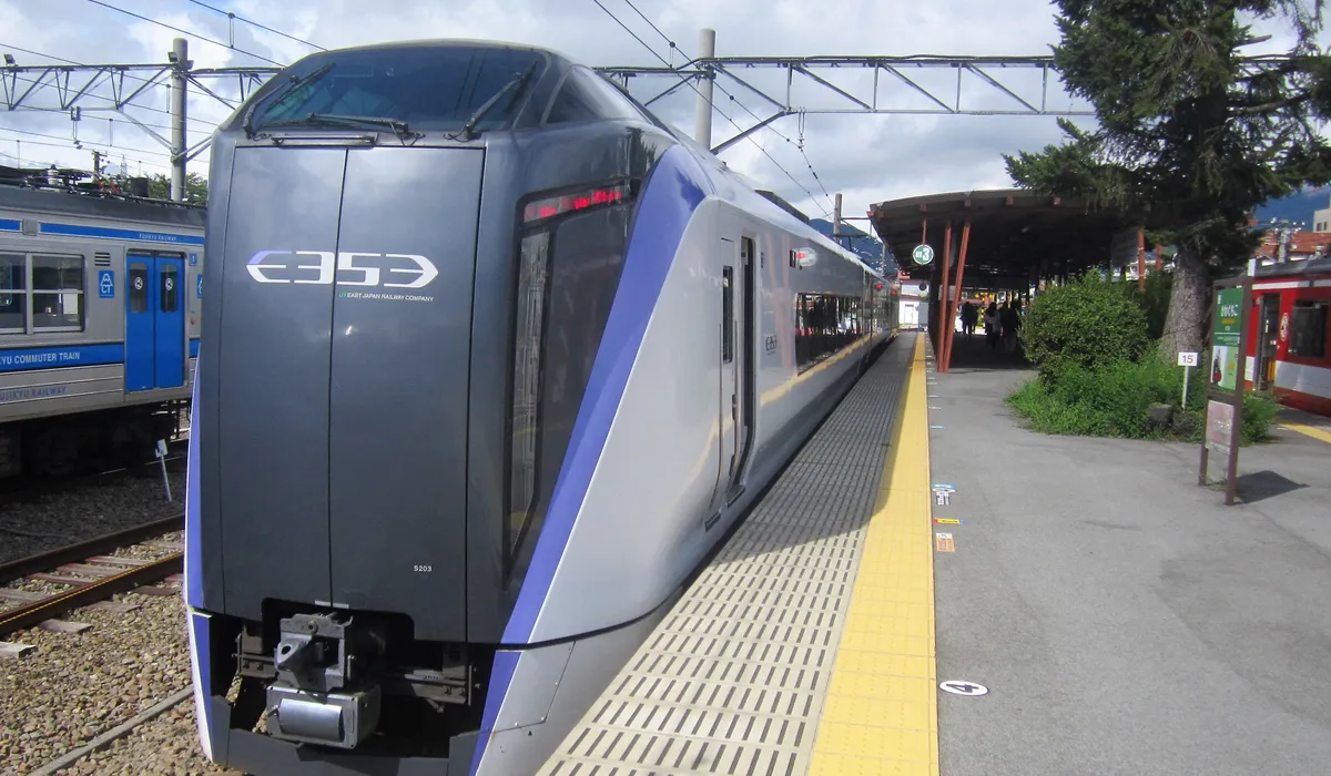 JR East limited express train arriving at a station near Mount Fuji