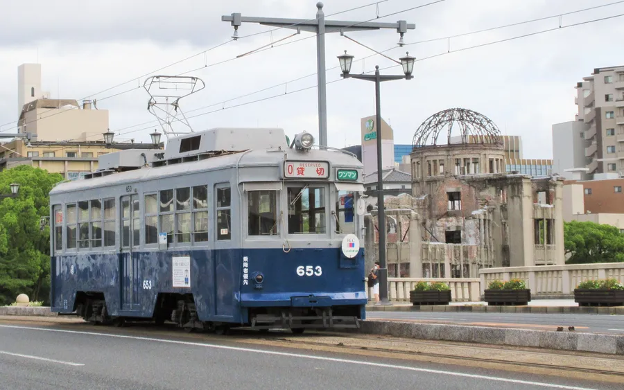 Hiroden 650-series streetcar (one of the surviving hibaku densha) with the Atomic Bomb Dome behind