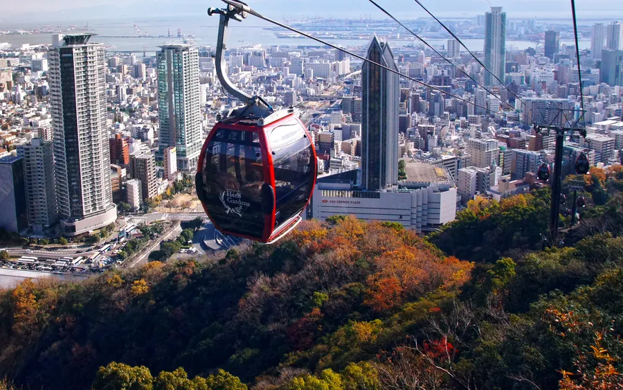 Ropeway gondola ascending to the Kobe Nunobiki Herb Garden, with the city below