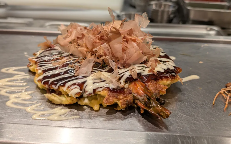 Okonomiyaki cooking on a griddle