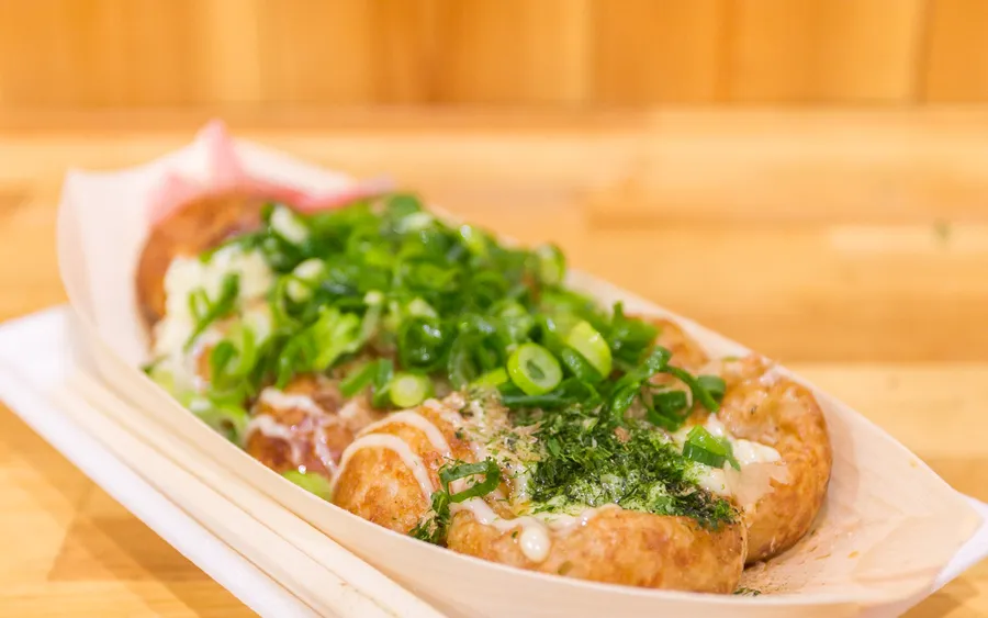 A serving of fresh takoyaki topped with bonito flakes
