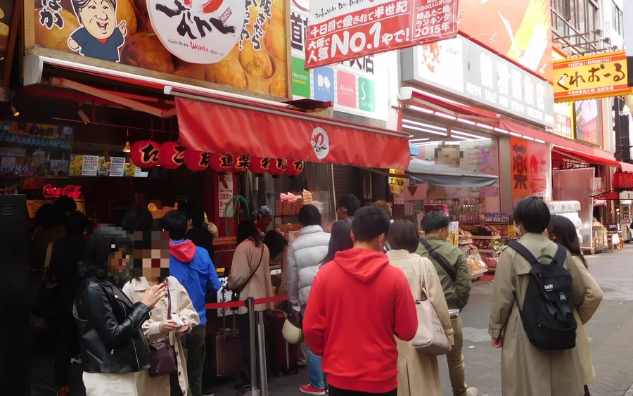 Customers lining up at a takoyaki stand in Osaka