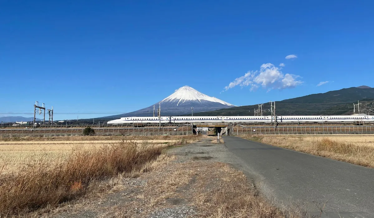 Shinkansen bullet train passing beneath Mount Fuji