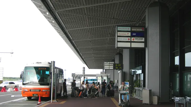 Airport limousine bus boarding passengers with luggage at a Narita terminal
